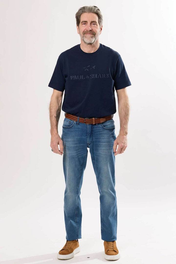 Homme portant un jean coupe droite avec un t-shirt navy, ce look décontracté allie confort et style.