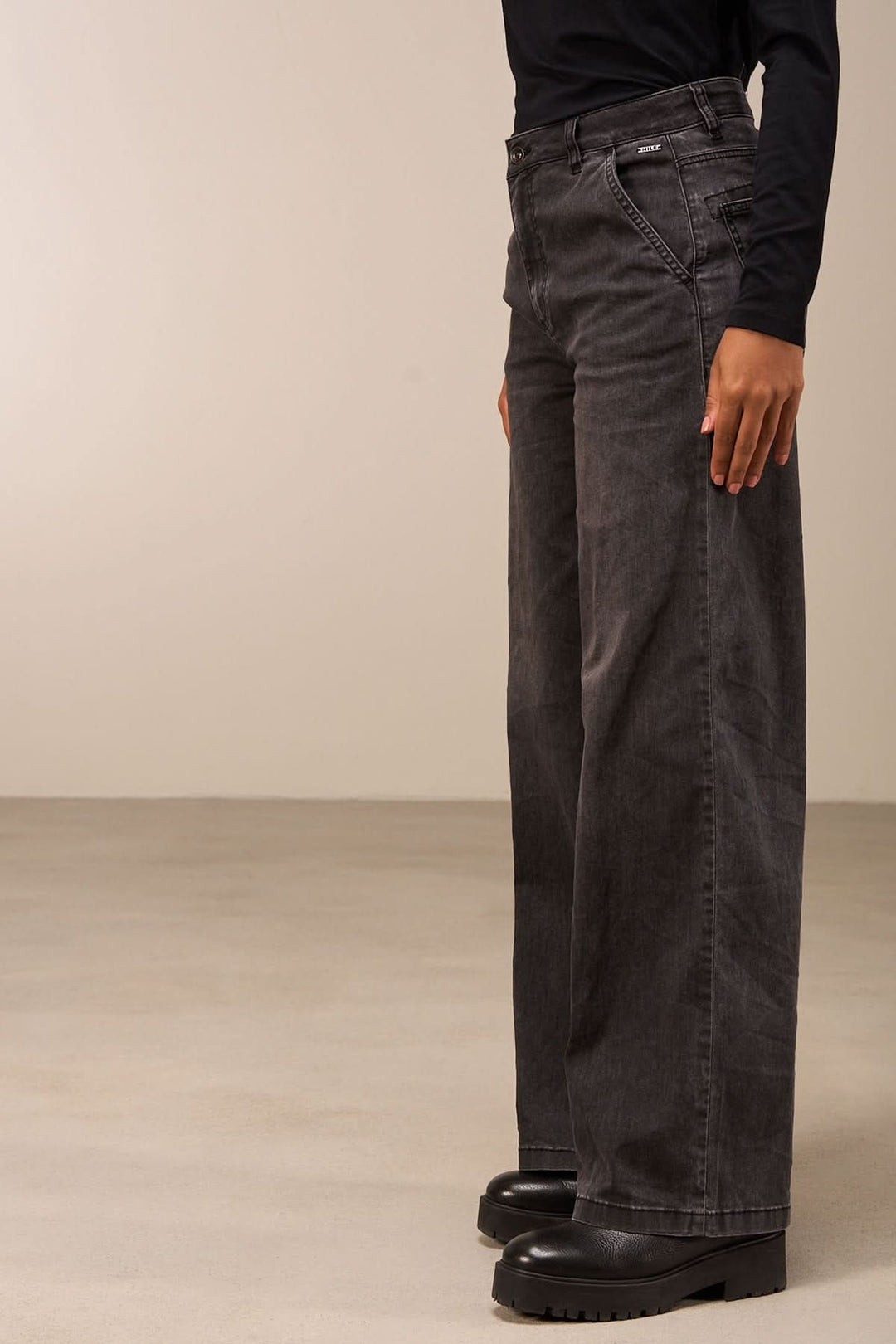 Vue latérale d'un jean coupe large gris foncé avec taille mi-haute et jambes amples, idéal pour un look décontracté ou habillé.