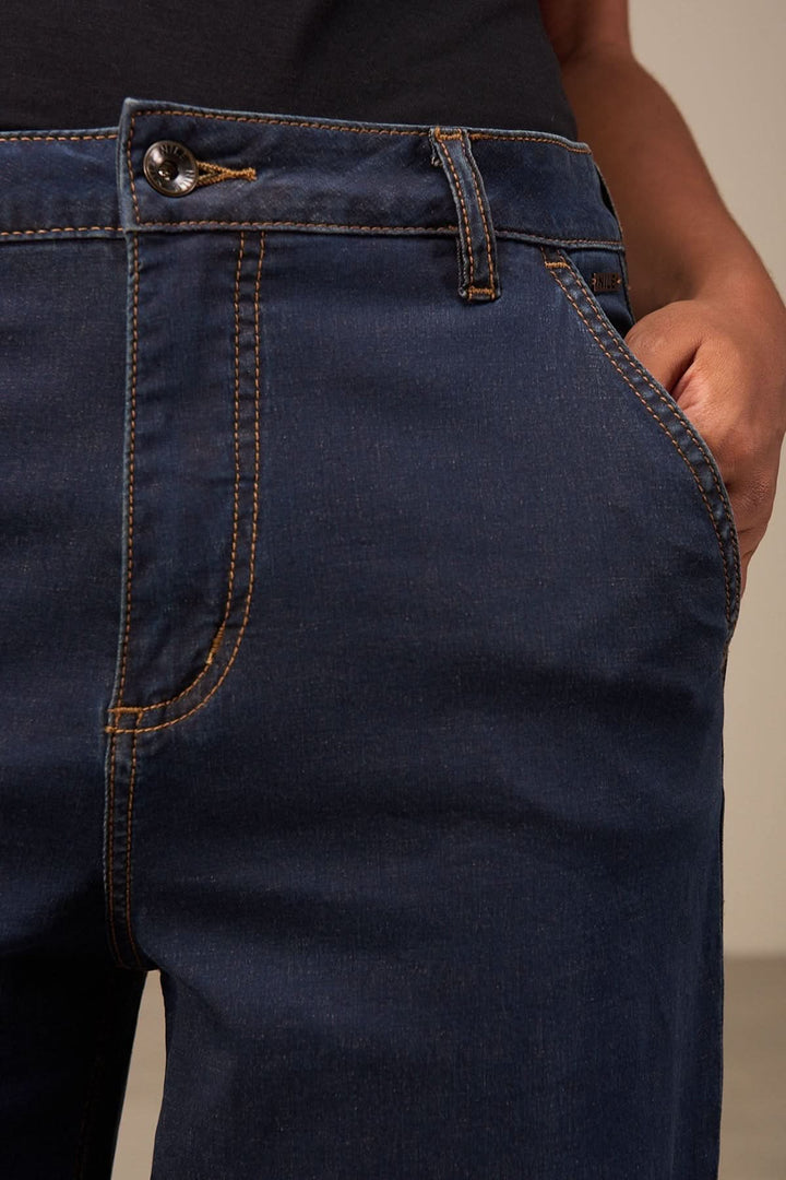 Jean coupe large en denim bleu avec taille mi-haute, poches et fermeture à bouton, idéal pour un look polyvalent et confortable.