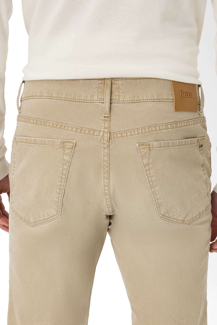 Jean moderne beige avec arrière détaillant les poches et la ceinture, style décontracté.