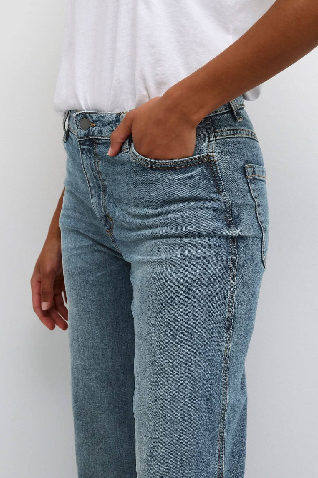 Jean droit Dana en denim bleu porté, avec poches avant, parfait pour un style décontracté ou chic.