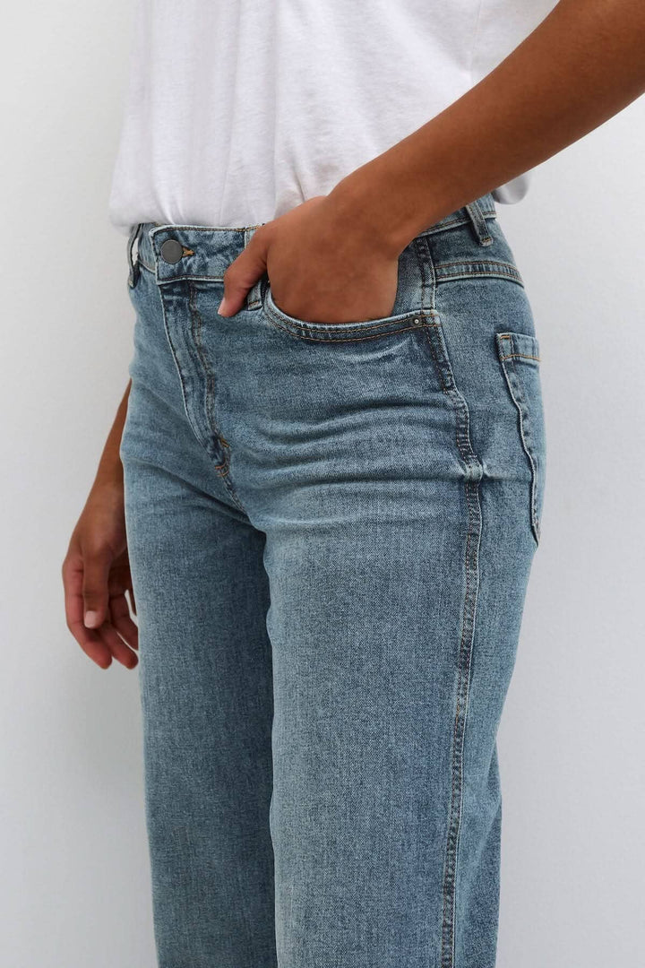 Jean droit Dana en denim bleu porté, avec poches avant, parfait pour un style décontracté ou chic.
