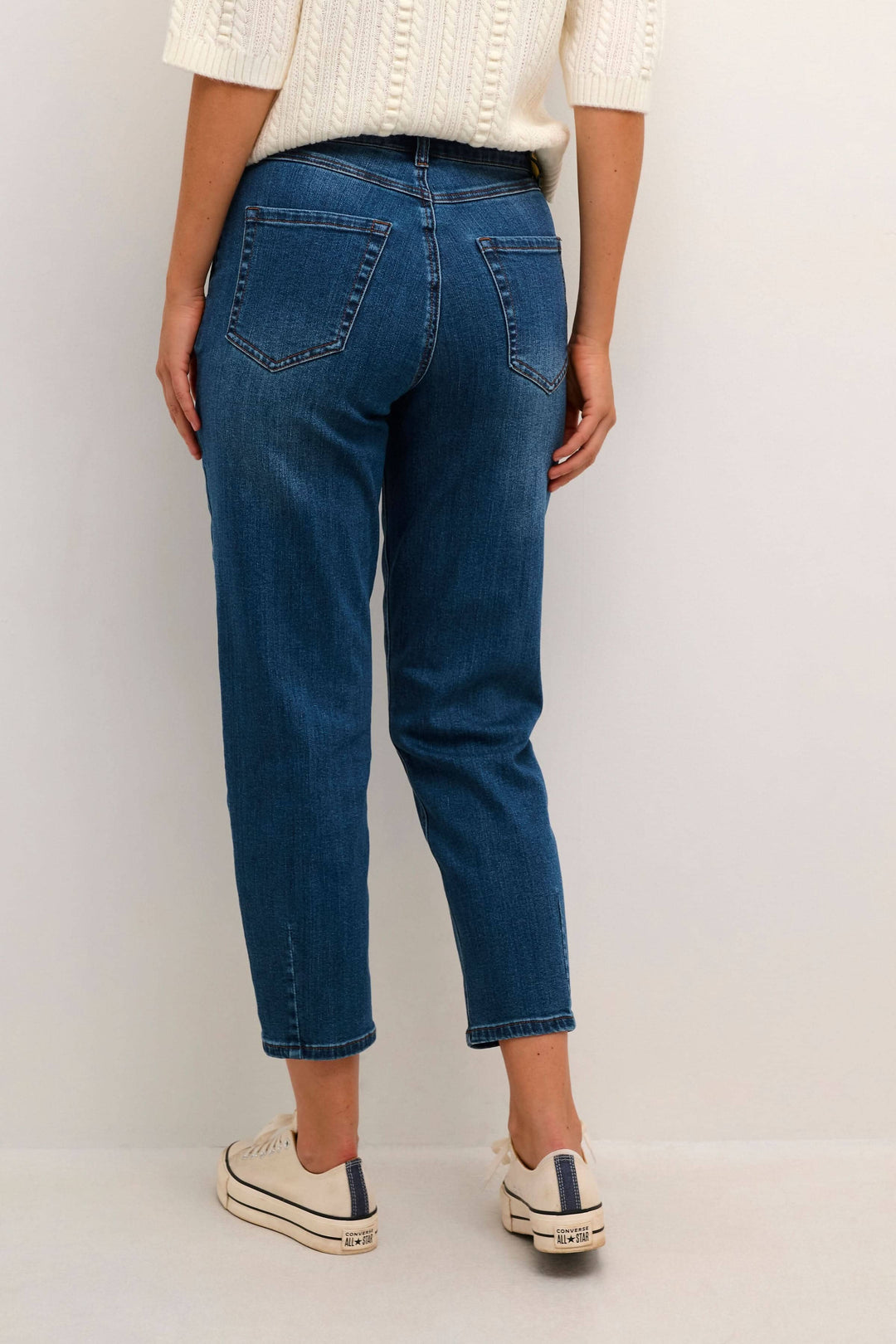 Femme portant un jean droit Sinem, vue arrière, longueur cheville avec des baskets, style décontracté.