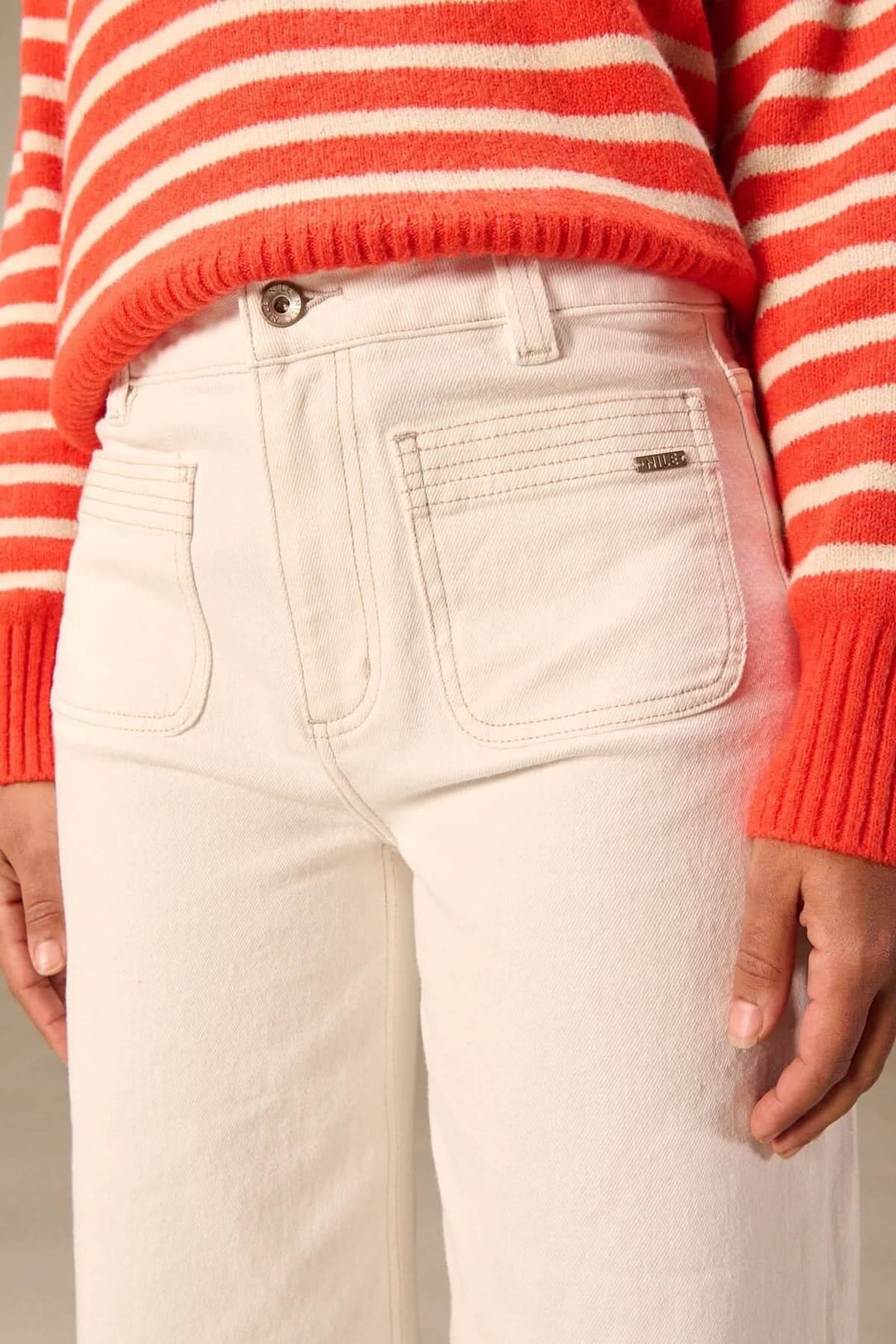 Jean jambe large blanc avec taille haute et poches appliquées, offrant un look moderne et structuré. Confort et style au quotidien.