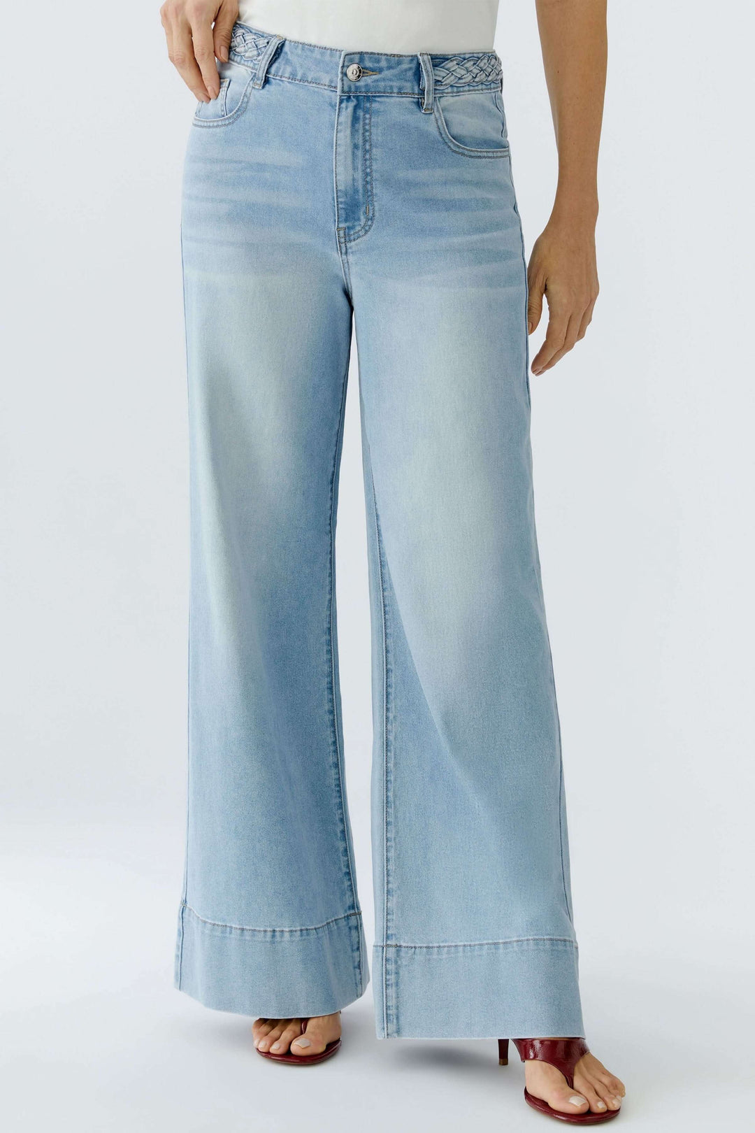 Jean à jambe large avec taille tressée, offrant une silhouette moderne et élégante, avec poches et passants pour ceinture. Confort et style.