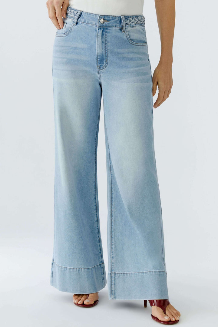 Jean à jambe large avec taille tressée, offrant une silhouette moderne et élégante, avec poches et passants pour ceinture. Confort et style.