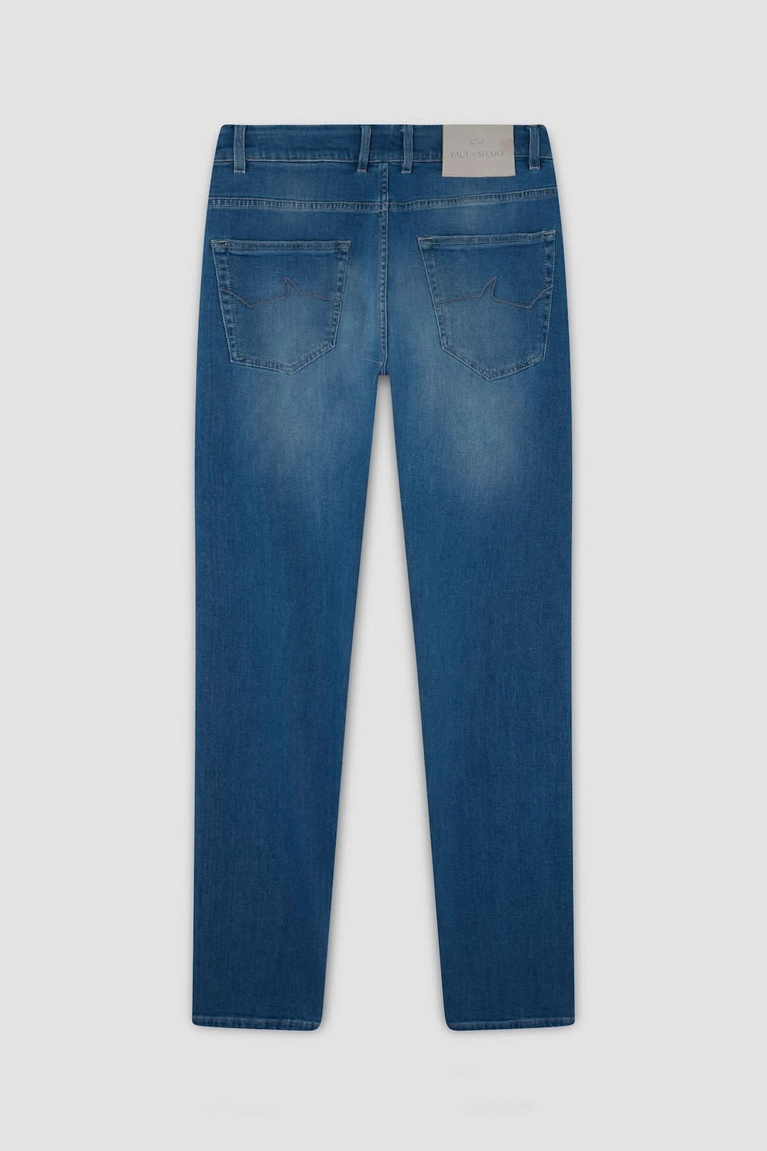 Jean premium coupe droite en tissu légèrement délavé, avec détails signature et pendentif métallique requin.