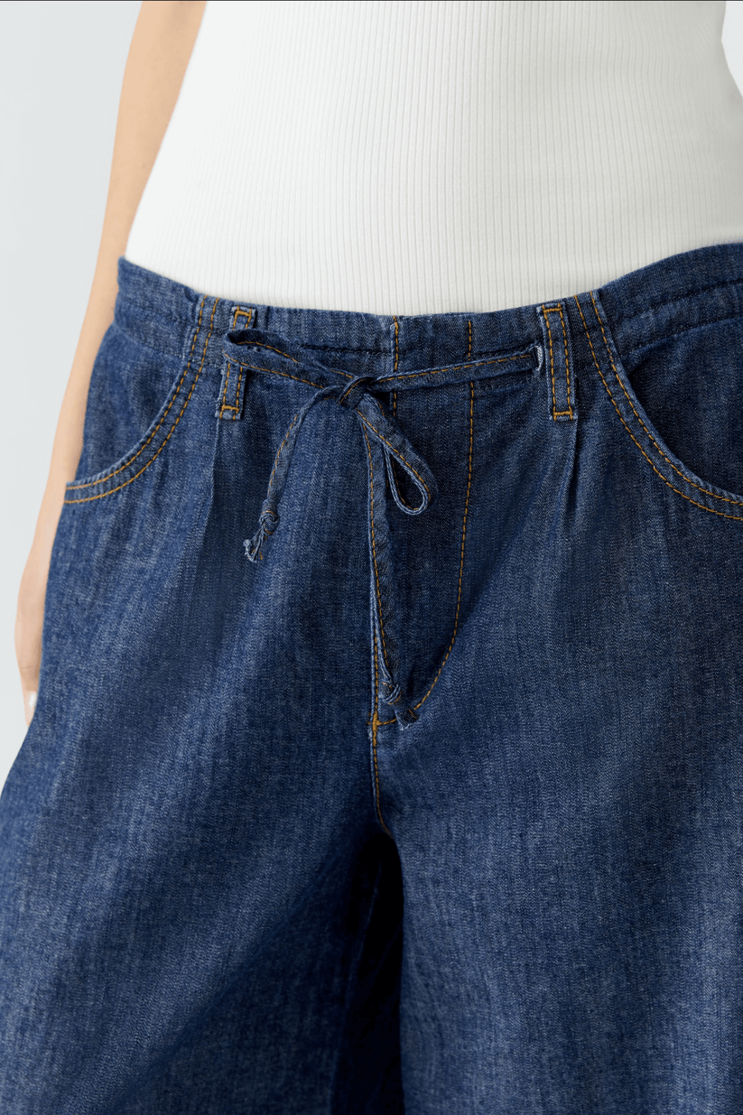 Jean ultra léger à taille mi-haute avec ceinture à cordon, coupe décontractée et moderne.