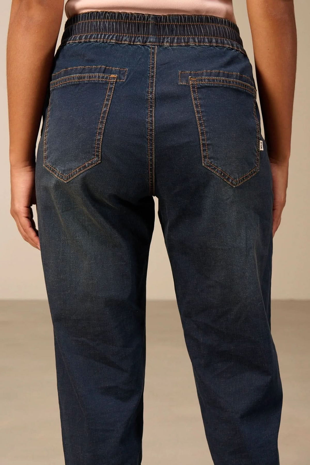 Vue arrière du Jeanjogging à taille élastique, montrant une coupe fuselée moderne et confortable, denim avec poches arrières.