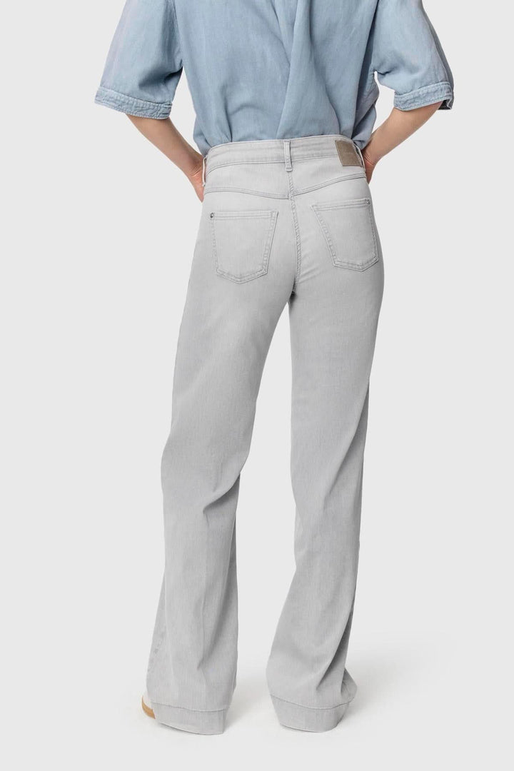 Jeans Dream Wide, pantalon à jambe large gris clair, vue arrière, taille mi-haute, tissu extensible, look casual avec chemise bleue.