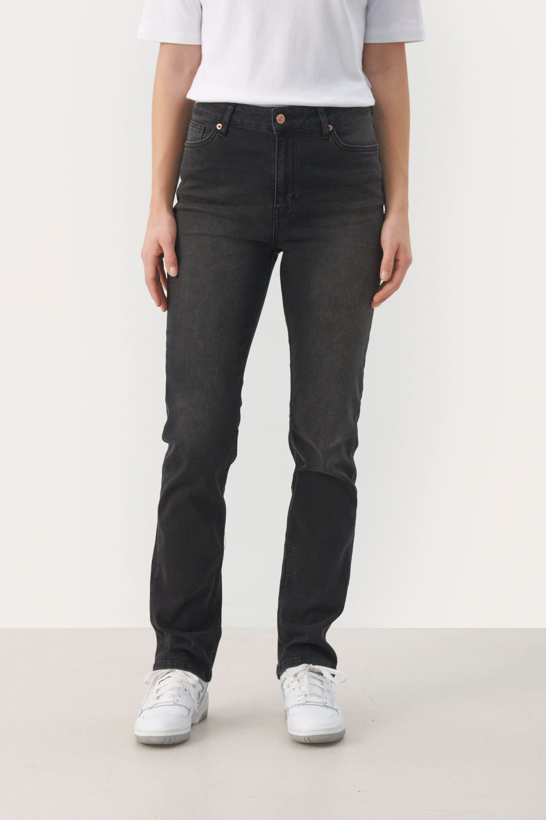 Jeans Ranas ajustés noir avec modèle classique à 5 poches, portés avec un t-shirt blanc et des baskets blanches.