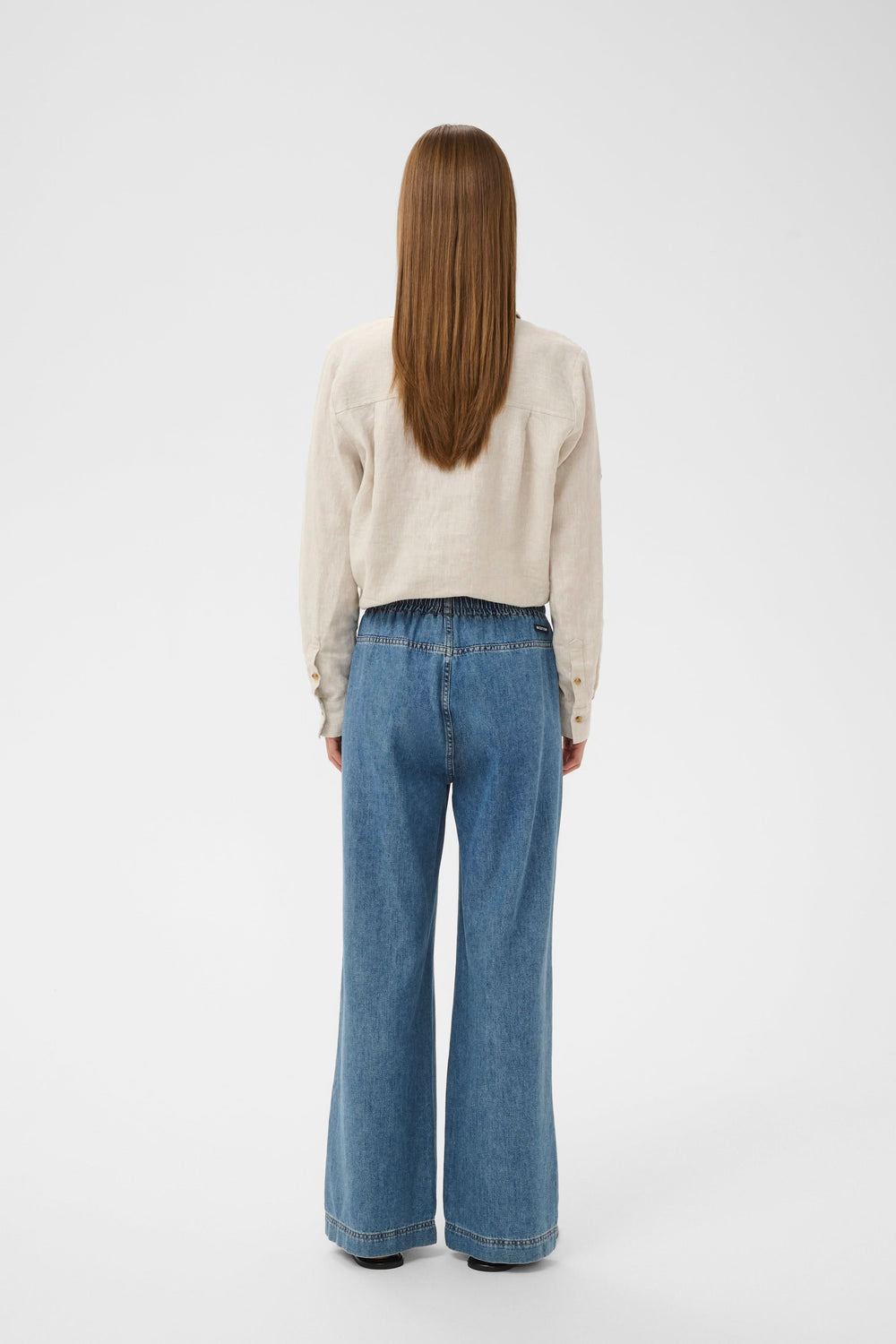 Vue arrière du Jeans Sophina taille élastique jambe large avec poches latérales et couture soignée. Tissu denim souple, look moderne.