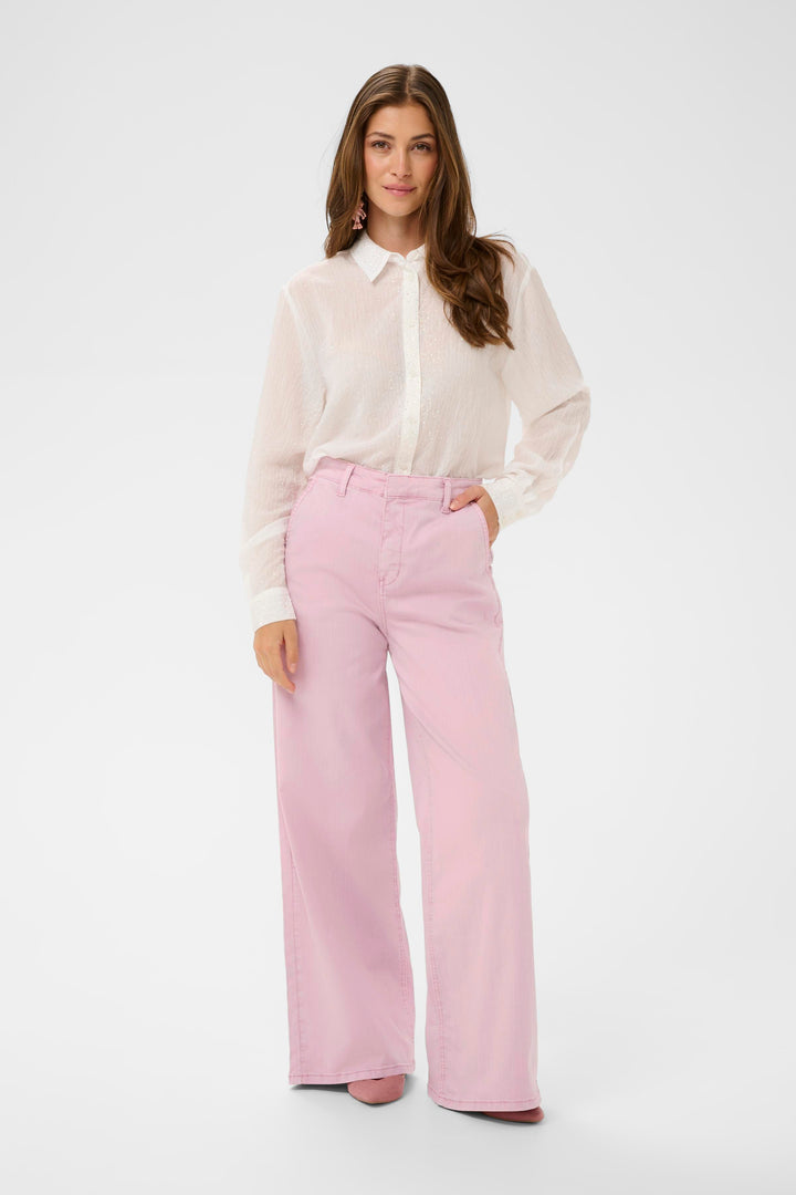 Femme portant un Jeans Visti rose à jambe large avec chemise blanche, silhouette moderne et élégante pour un look décontracté.