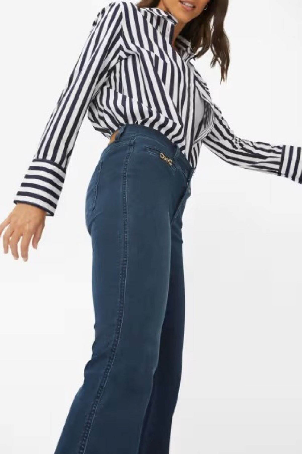 Femme portant des jeans bootcut SHAKIRA avec une chemise rayée, mettant en valeur la coupe évasée et le style unique.