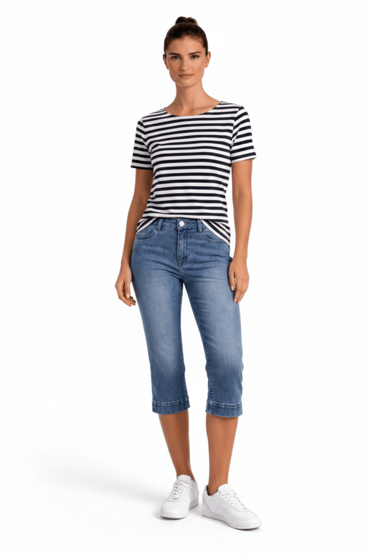 Femme portant un jeans capri ajusté, élégant et moderne, avec une coupe flatteuse pour un style estival décontracté.