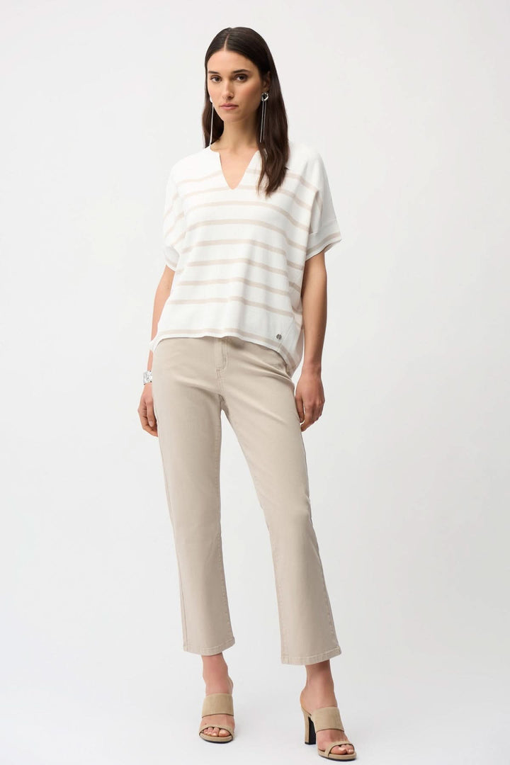 Femme portant un pull rayé blanc et beige et des Jeans droit longueur cheville beige avec des chaussures à talons.