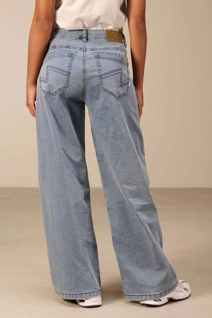 Vue arrière d'un jeans jambe large bleu clair avec taille haute et coupe évasée, offrant un style rétro et contemporain.