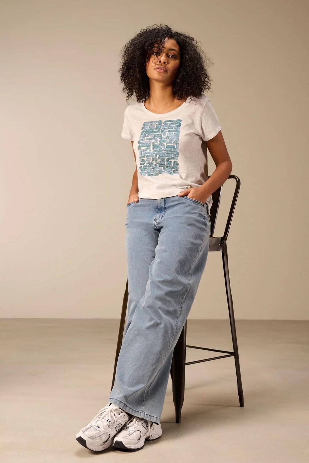 Jeans jambe large avec coupe évasée et taille haute, porté par une femme debout, parfait pour un style décontracté ou habillé.
