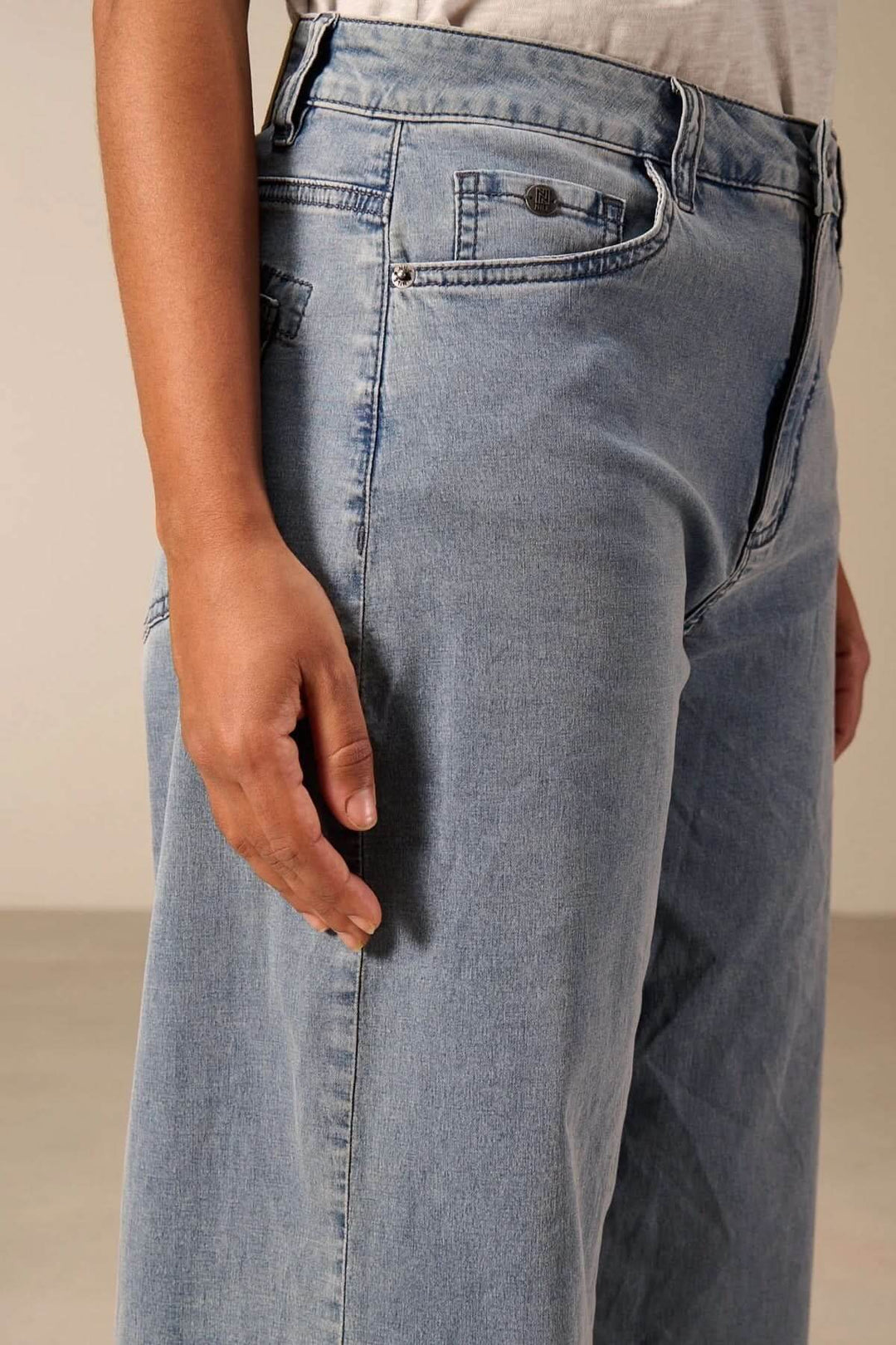 Jeans jambe large à taille haute, coupe évasée, vue de profil mettant en valeur la silhouette rétro et contemporaine.