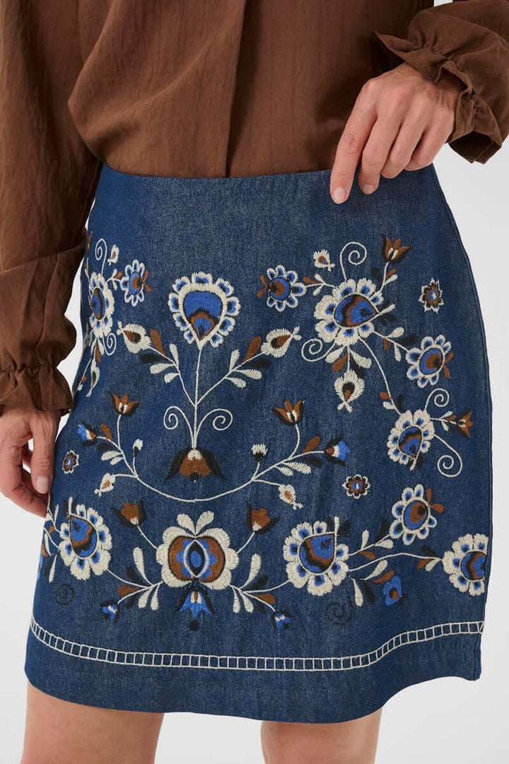 Jupe Gro en denim avec broderies florales contrastées, coupe droite bohème chic, élégante et décontractée.