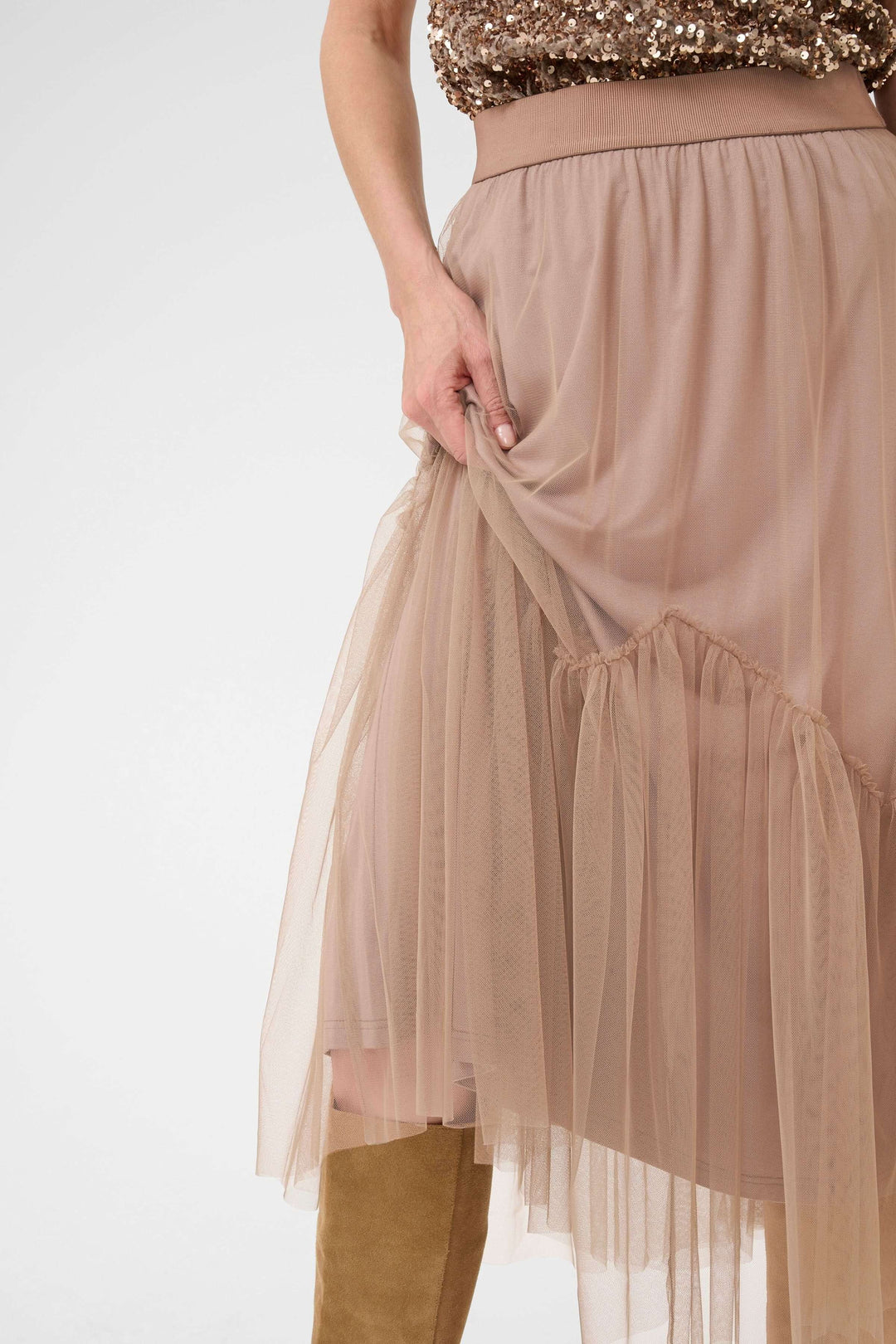 Jupe midi en tulle vaporeux avec empiècement froncé en forme de V, montrant sa fluidité et confort.