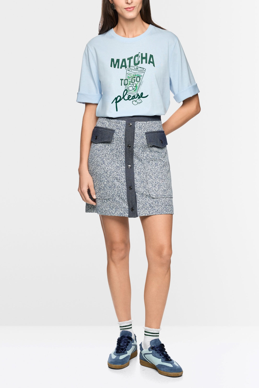 Jupe courte en viscose extensible avec fermeture boutonnée, poches à rabat, et t-shirt décontracté.