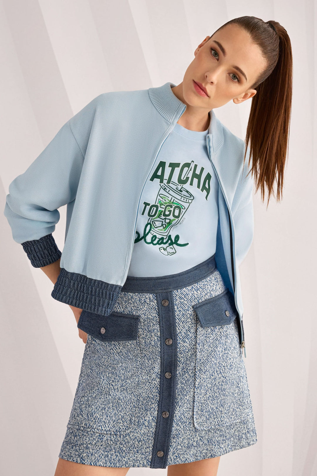 Femme portant une jupe courte en viscose extensible avec des poches à rabat et une fermeture boutonnée, style décontracté moderne.