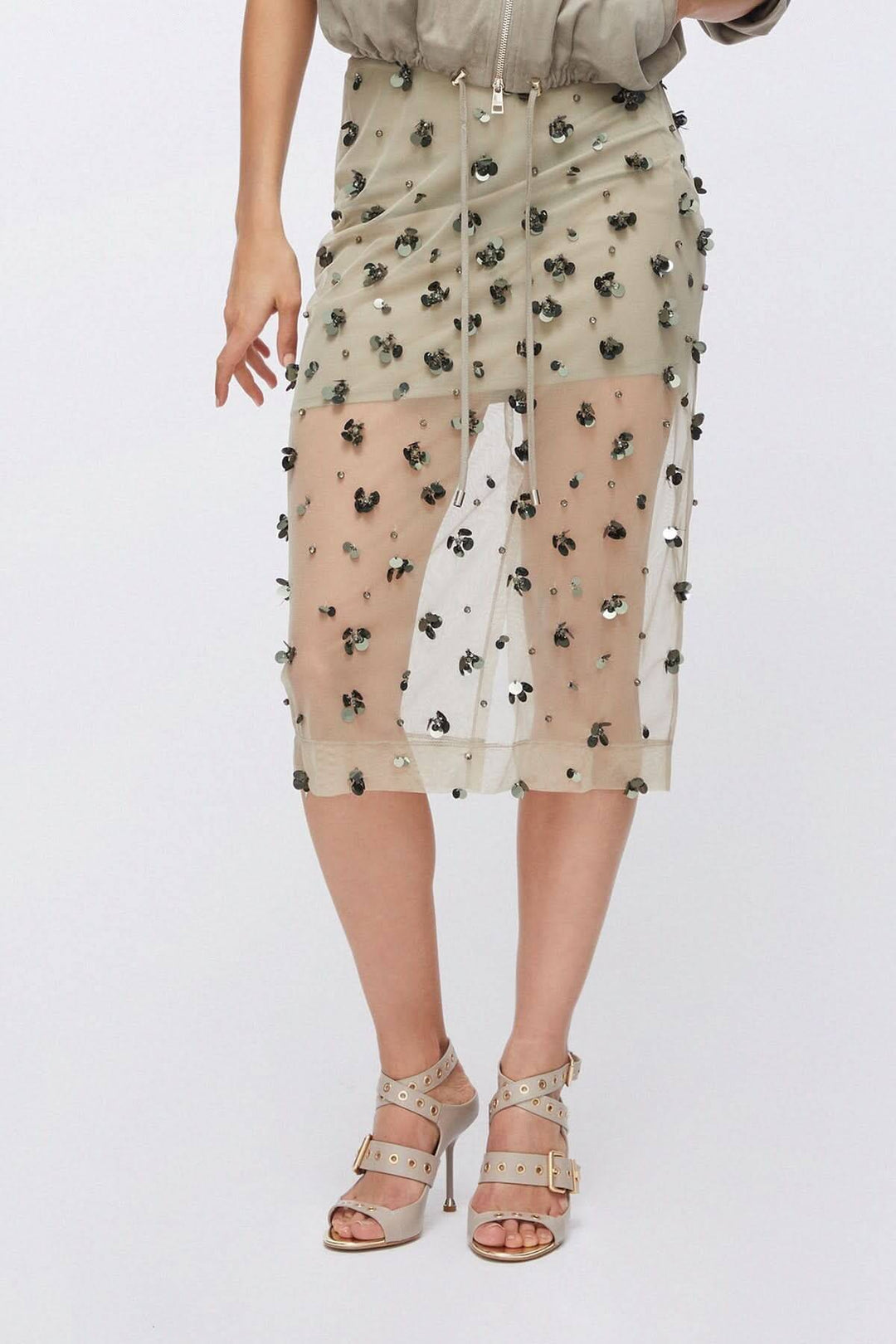 Jupe en maille transparente ornée avec détails appliqués et effet texturé, mode audacieuse pour tenues raffinées.