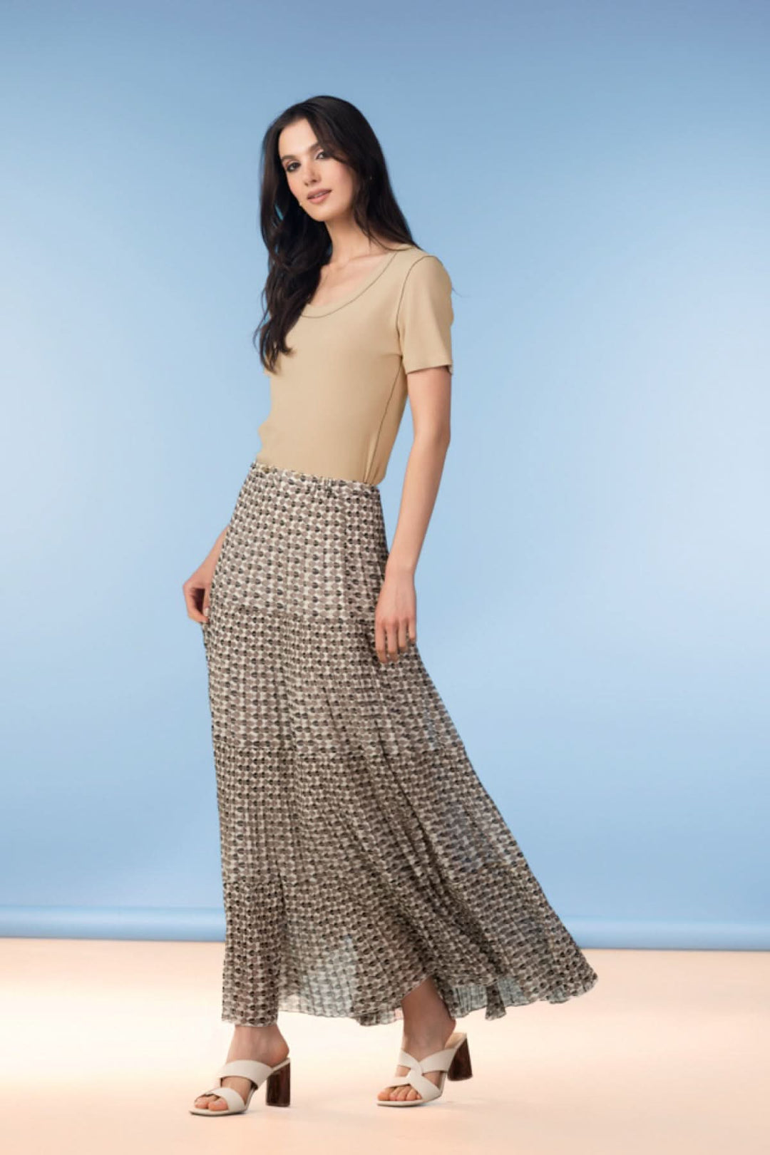 Femme portant une jupe longue fluide à imprimé graphique, mettant en valeur la silhouette avec élégance et confort.