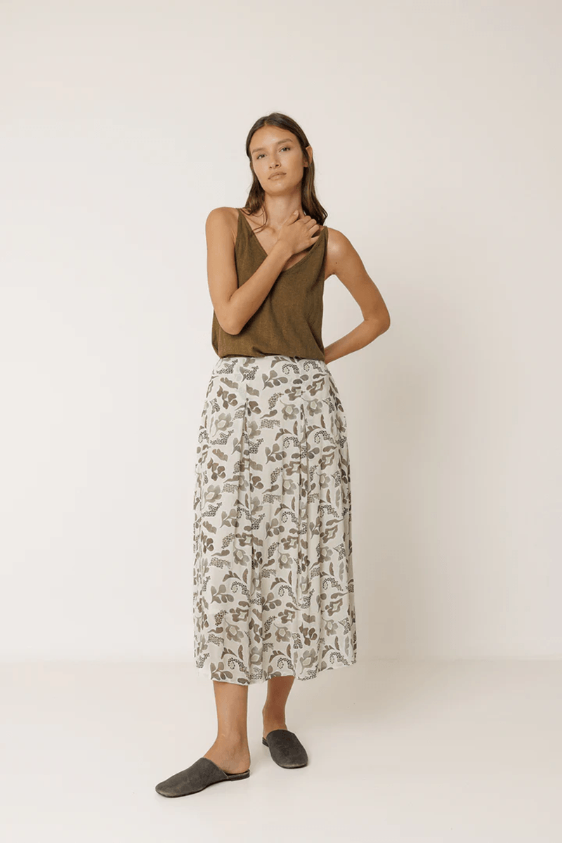 Femme portant une jupe longue imprimée fluide avec un imprimé délicat, mettant en valeur une silhouette élégante et naturelle.