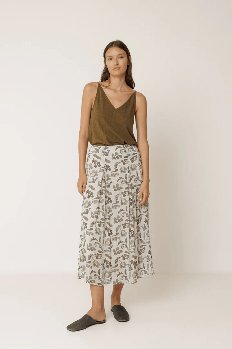 Jupe longue imprimée fluide portée par une femme élégante, coupe évasée et tissu léger pour un look décontracté et raffiné.