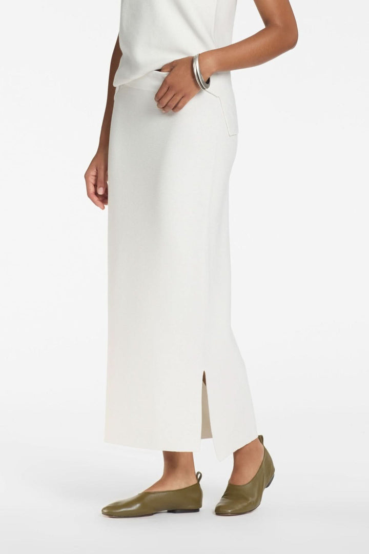 Femme portant une jupe longue minimaliste à fente, silhouette épurée et moderne, idéale pour un look élégant et confortable.