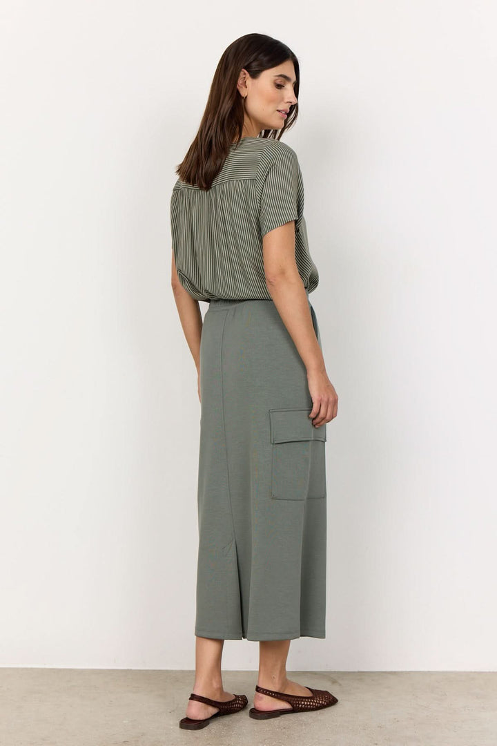 Femme portant une jupe longue souple en modal avec poches, vue arrière, style décontracté.