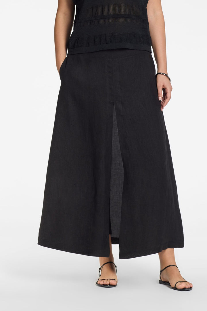 Jupe longue trompe-l’œil à effet portefeuille en noir avec fente à l’avant et poches latérales, silhouette fluide et élégante.