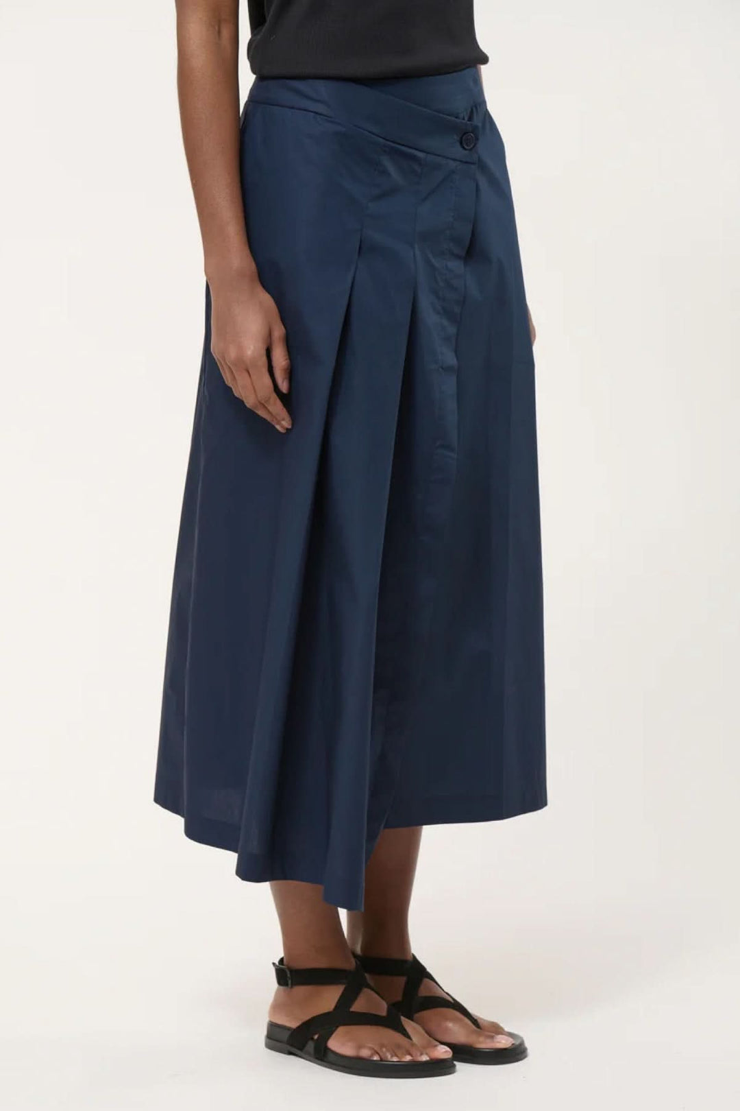 Jupe midi portefeuille élégante avec plis marqués, idéale pour une allure sophistiquée et confortable.