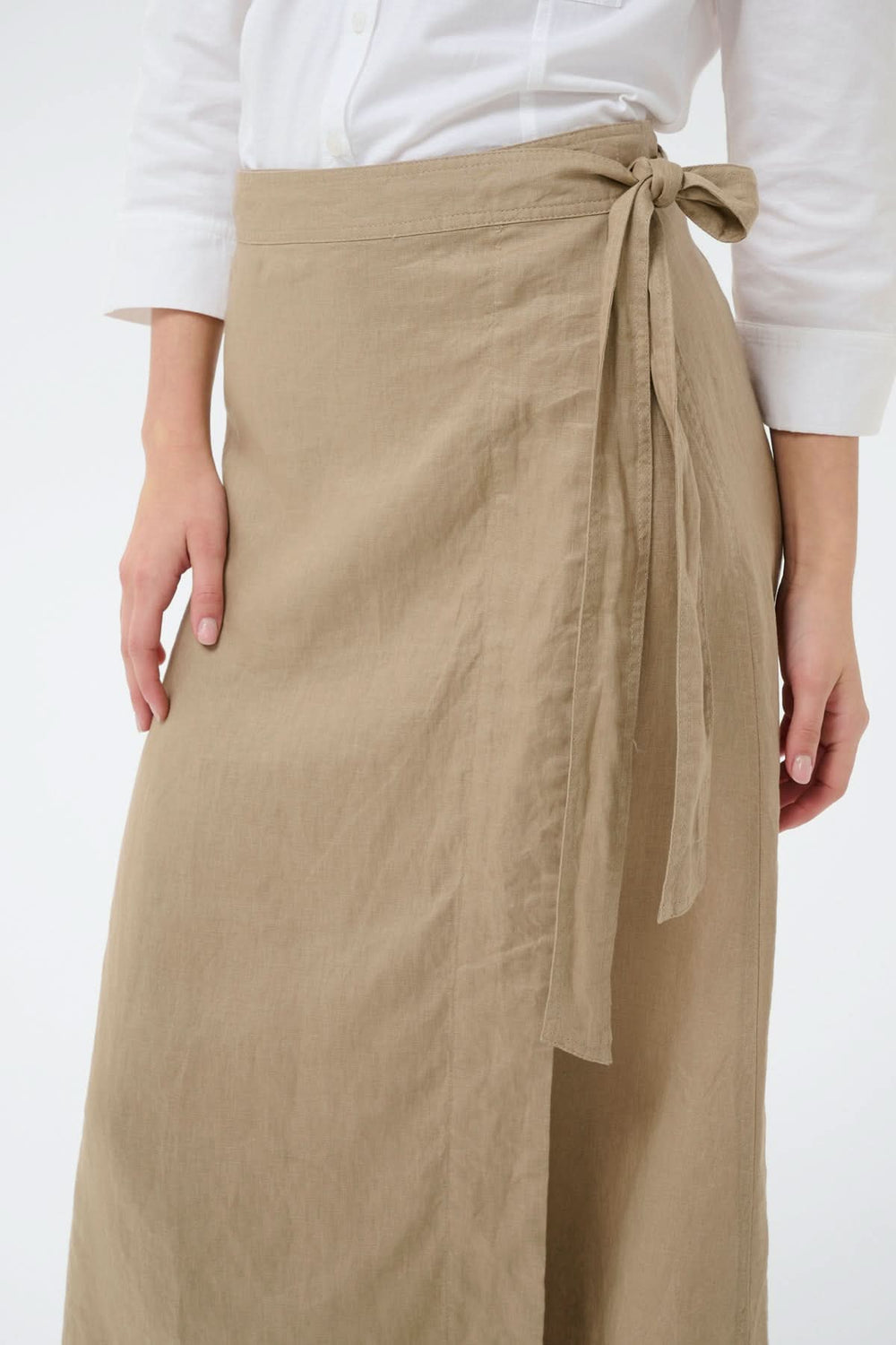 Jupe porte-feuille Arbella en lin beige avec taille ajustable et lien à nouer, offrant une silhouette fluide et élégante.
