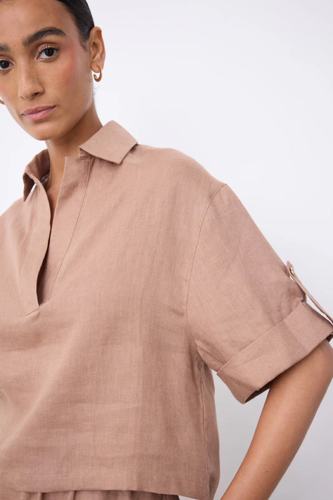 Blouse courte en lin à col ouvert, V-neck, lightweight linen fabric, short sleeves with cuffs, modern silhouette. Décris moi le produit en français.