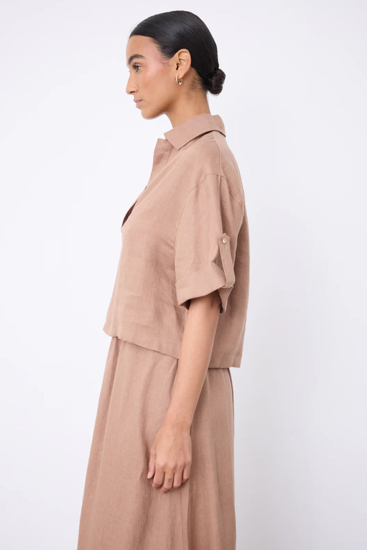 Blouse courte en lin à col ouvert vue de côté, manches courtes, tissu léger et respirant, idéale pour l'été.