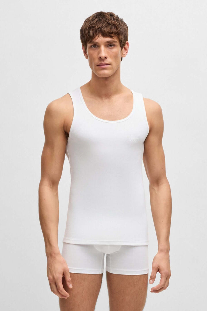 Homme portant un débardeur blanc BOSS, Coupe ajustée en coton doux, idéal comme sous-vêtement ou à la maison.