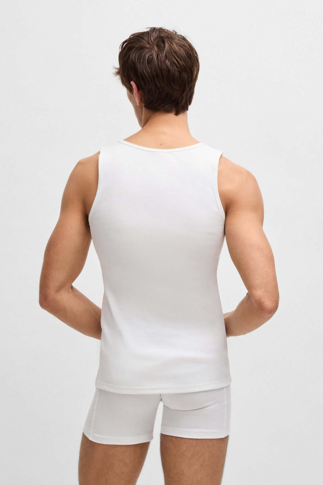 Homme vu de dos portant un débardeur blanc BOSS avec une coupe ajustée et un logo discret.