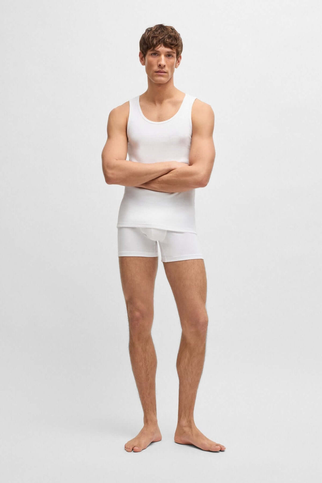 Homme en débardeur blanc et boxer, mettant en valeur confort et style décontracté.