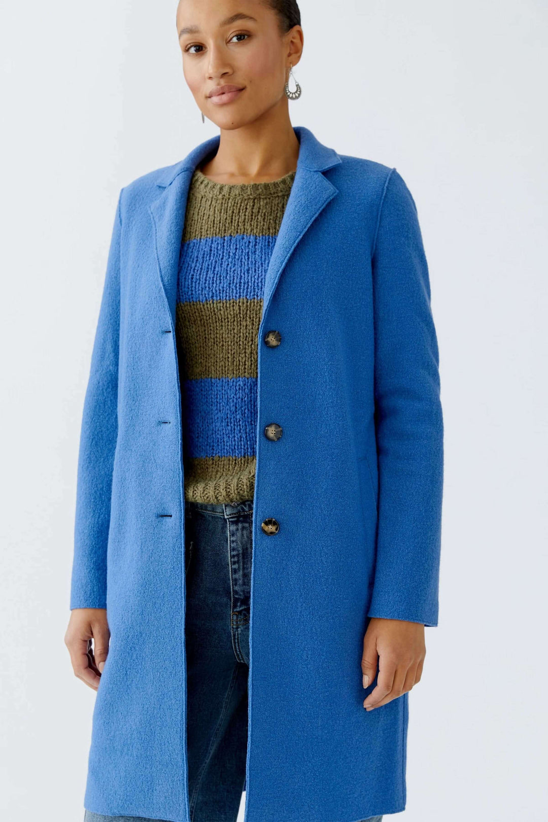 Manteau Mayson bleu, élégant et moderne, porté sur un chandail en maille pour un style chic et décontracté.