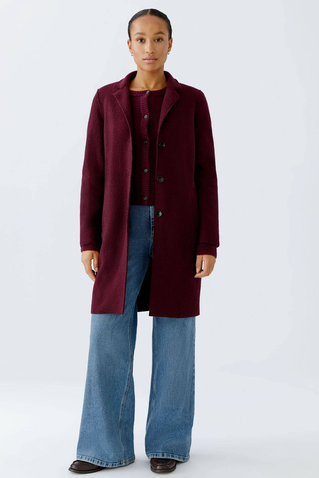 Manteau Mayson en bordeaux, porté avec un chandail en maille et jean pour un look chic et décontracté.