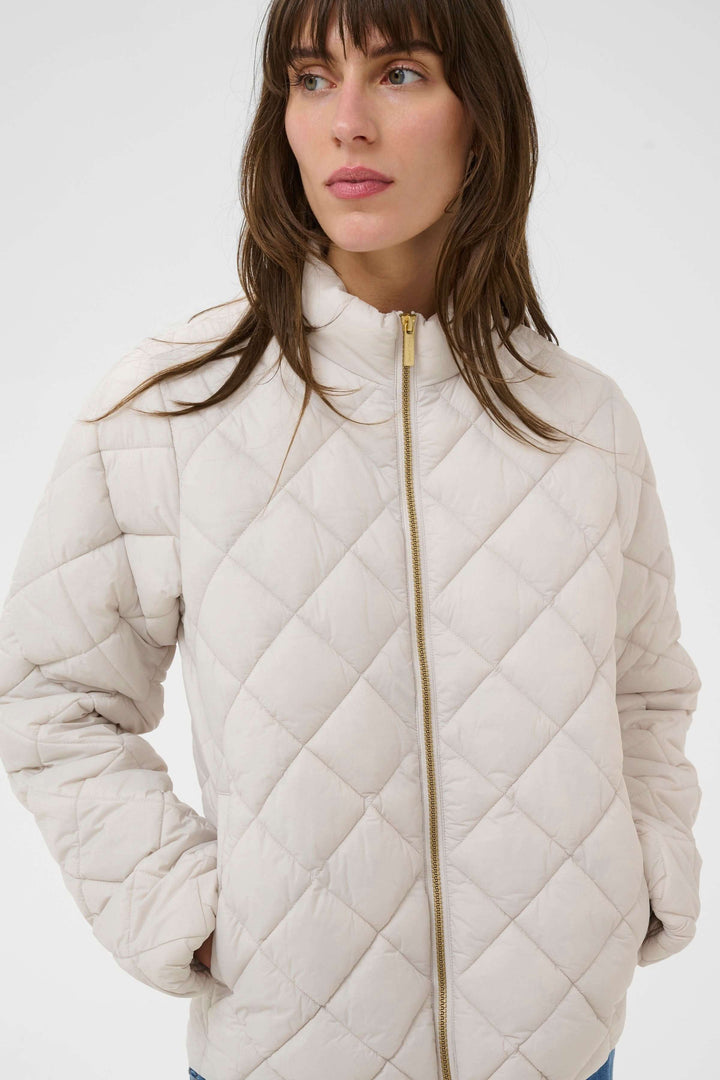 Femme portant un Manteau Olia matelassé, coupe droite et col montant, confortable pour les journées fraîches.