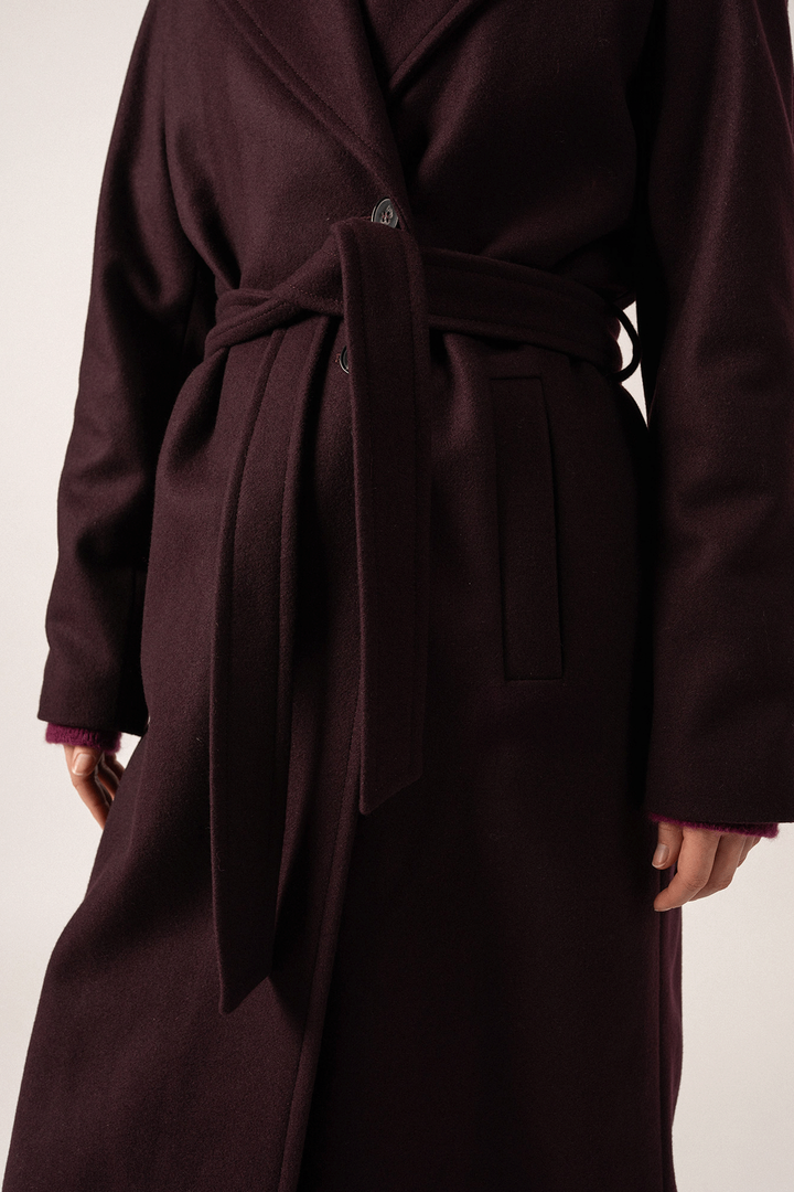Manteau St-Enora en laine, couleur bordeaux, avec ceinture réglable et poches, élégant et confortable.