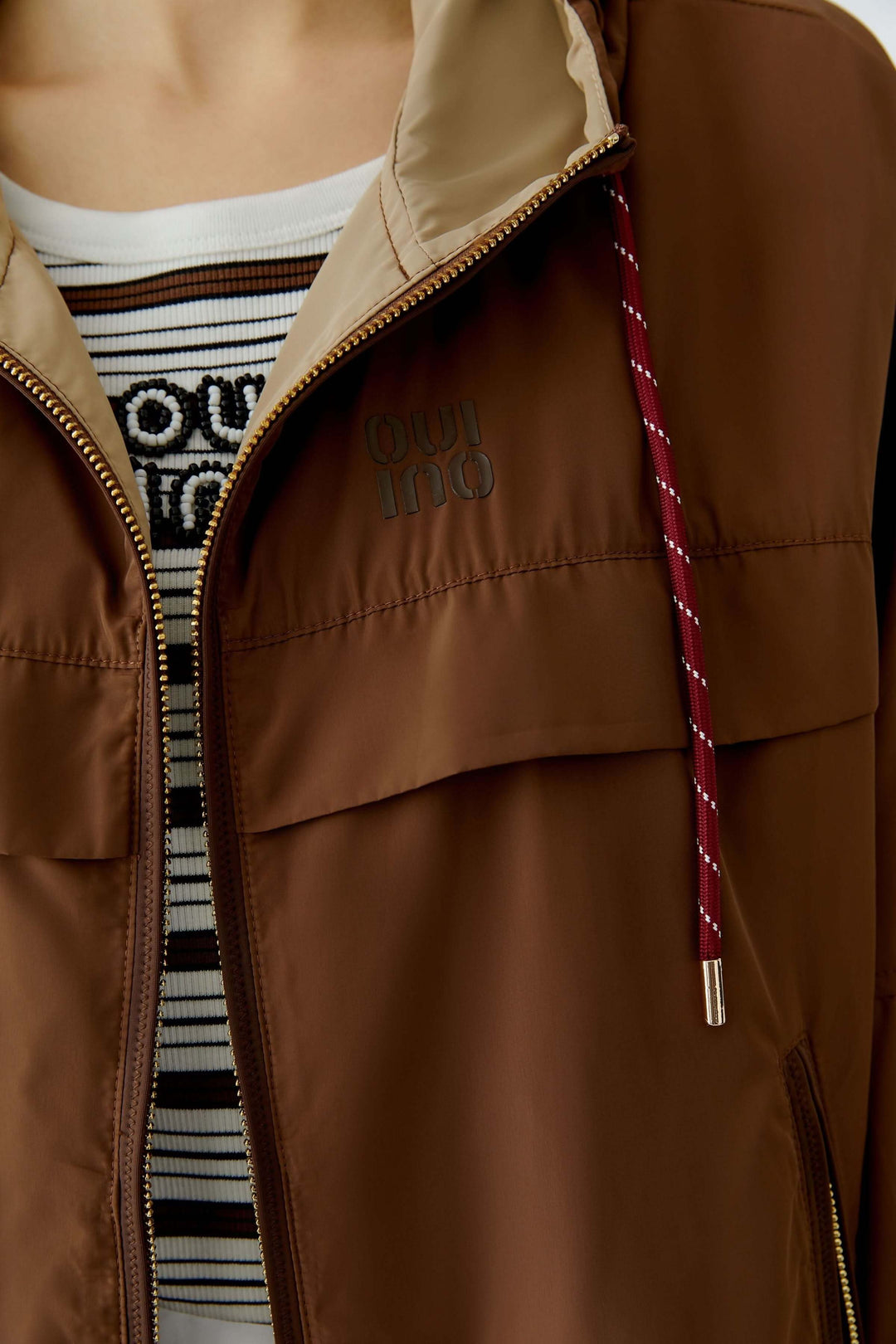 Manteau léger à capuchon marron avec fermeture éclair et cordon ajustable, idéal pour la mi-saison et le style décontracté.