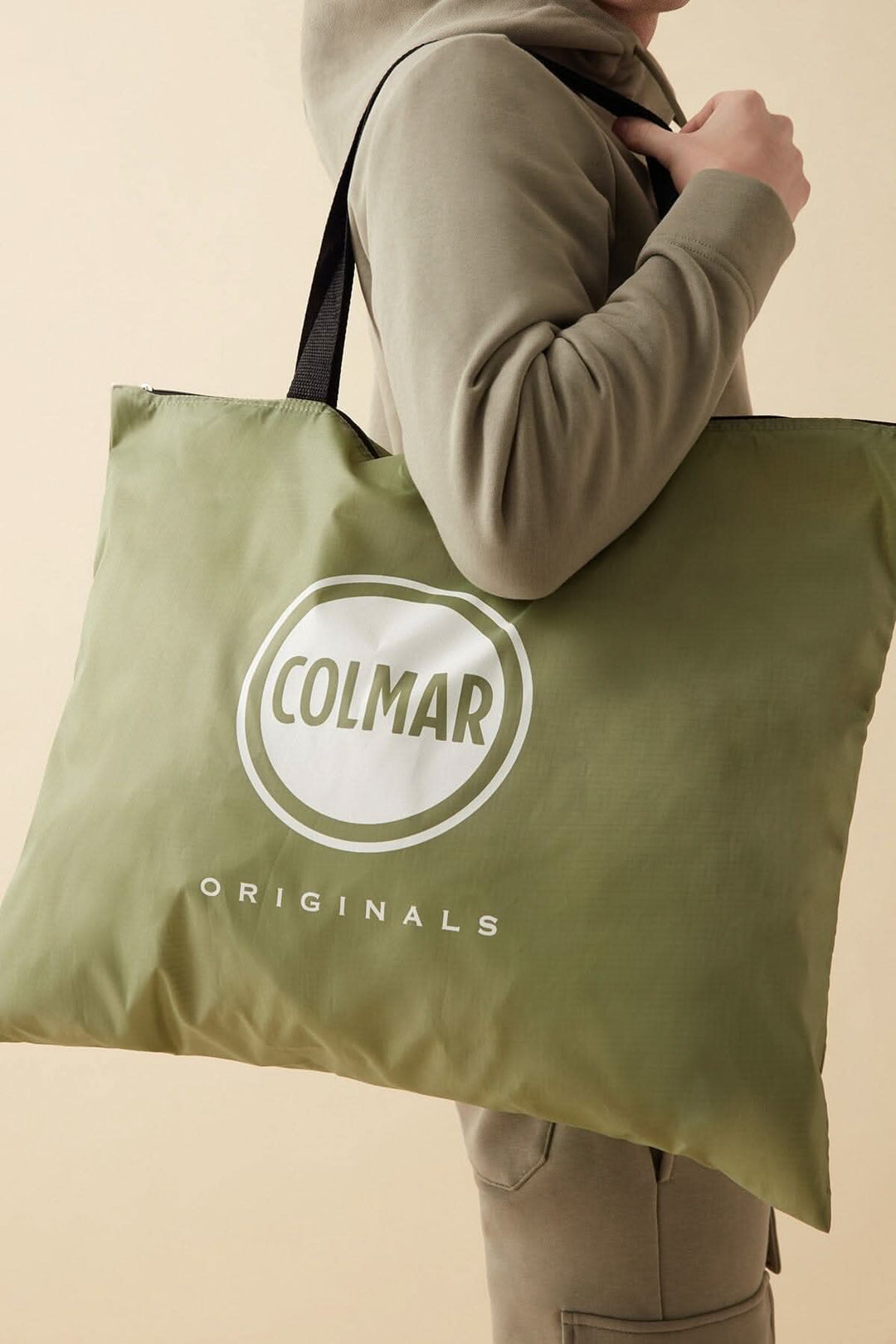 Sac fourre-tout Colmar Originals en vert avec logos, porté par un homme, style décontracté.