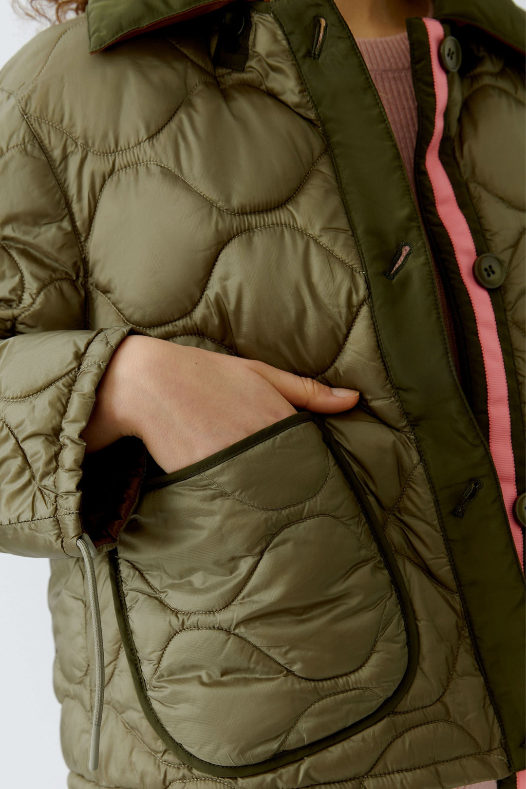 Manteau réversible matelassé avec poches contrastantes, offrant un look élégant et moderne idéal pour toutes les saisons.