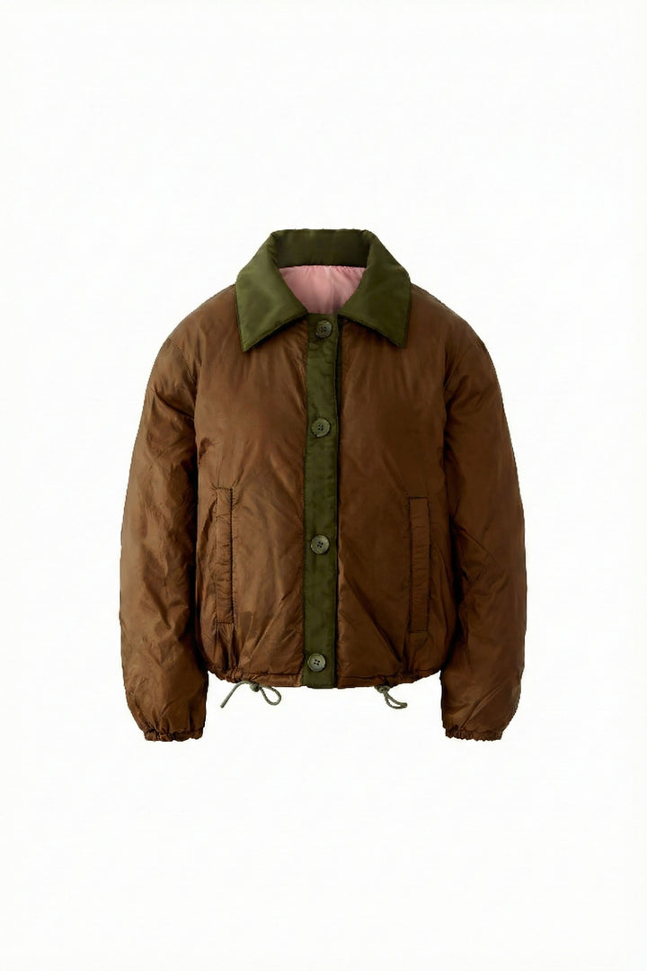 Manteau réversible matelassé marron avec col contrastant et fermeture boutonnée, offrant confort et style moderne pour les saisons.