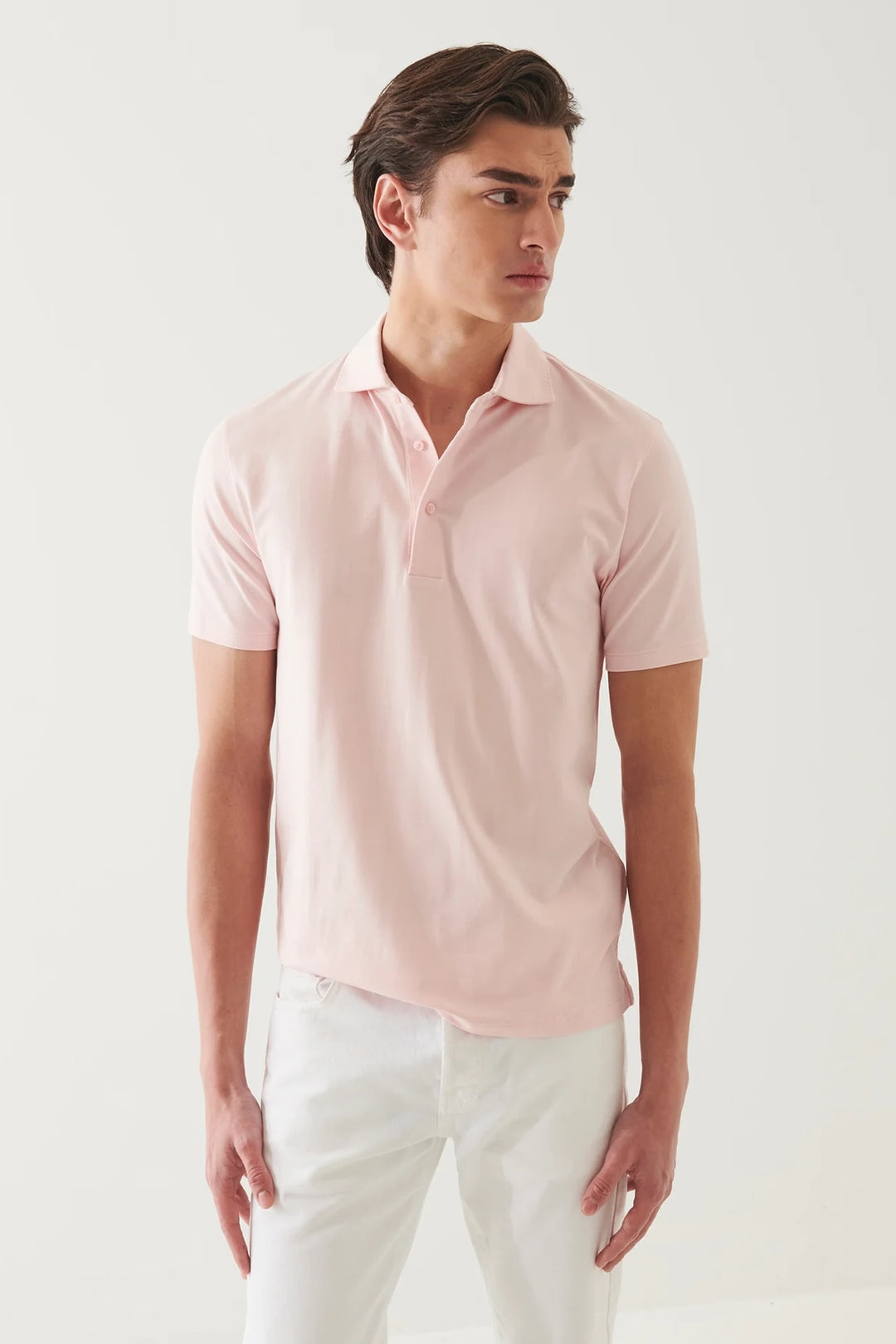 Homme portant un polo à manches courtes roses, style épuré, confort doux et respirant.